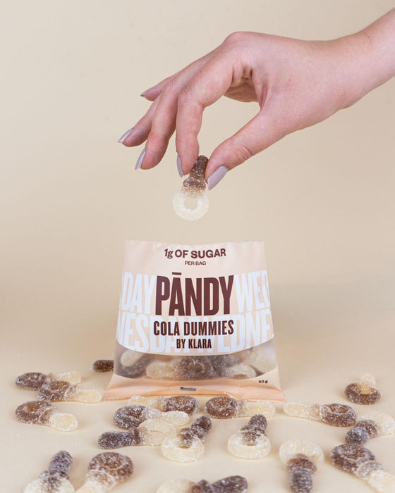 PANDY Candy cola-flavored gummy candies with a gummy being dropped into the bag