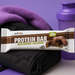 PER4M Protein Bar on gym bag with purple towel and shaker – On-the-Go Fuel lifestyle image for MySupplementShop ecommerce listing.