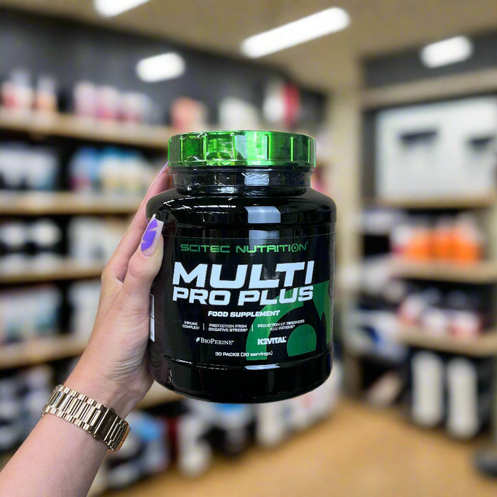 Close-up of (SciTec Multi Pro Plus - 30 packets) held up inside My Supplement Shop, clearly showing the front label in a Sports Nutrition setting.
